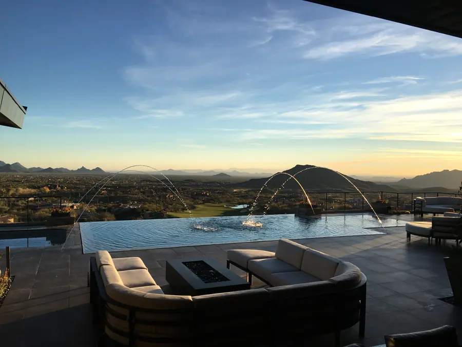 Pool with arcing fountains overlooking a wide desert valley