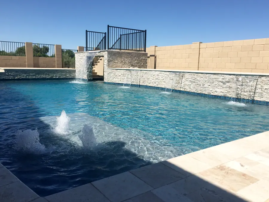 Pool with a stone water wall, waterfall, and fountain