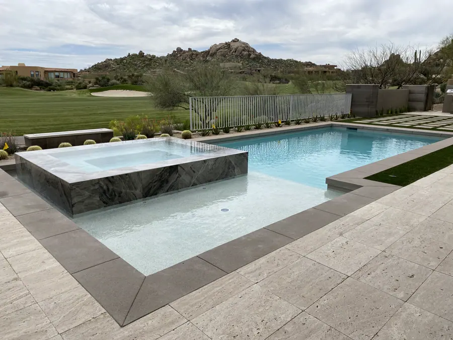 Rectangular pool and raised spa beside a lawn and mountain view